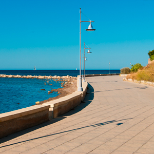 Conjuntos con columna y brazo poliméricos, y luminaria Pescador de ATP en zona costera, manteniendo su aspecto original con el paso del tiempo.