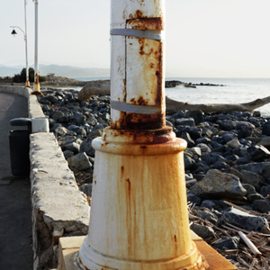 Alumbrado metálico deteriorado por la corrosión en primera línea de costa.