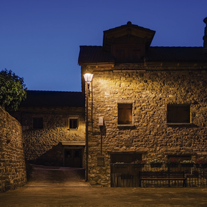 Fachadas de piedra del casco urbano realzadas por una iluminación cálida y uniforme, en armonía con la identidad rural.