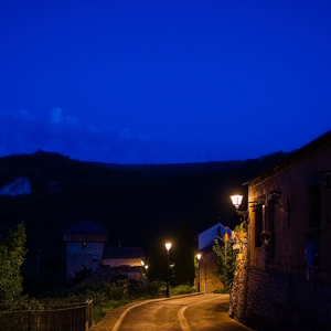 Vista panorámica nocturna de Sinués, con iluminación cálida y mínima dispersión lumínica en plena alta montaña.