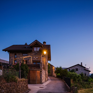Transición del día a la noche en Sinués, con luminarias clásicas Villa XLA integradas en la arquitectura del valle de Aísa.