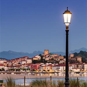 El farol cl&aacute;sico antivand&aacute;lico Litoral A realza el perfil urbano nocturno de San Vicente de la Barquera con uniformidad lum&iacute;nica.